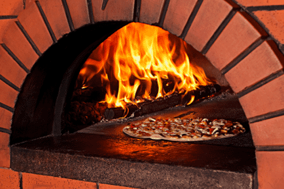 Cooking a pizza in a brick oven.