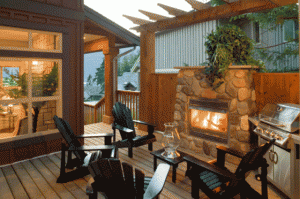 Picture of a wood deck with table, charis and outdoor fireplace.